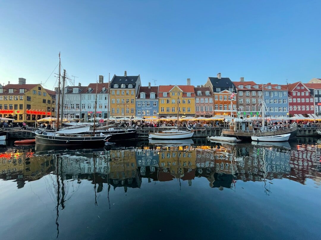 Colorful harbor houses reflected in water in Nyhavn Copenhagen