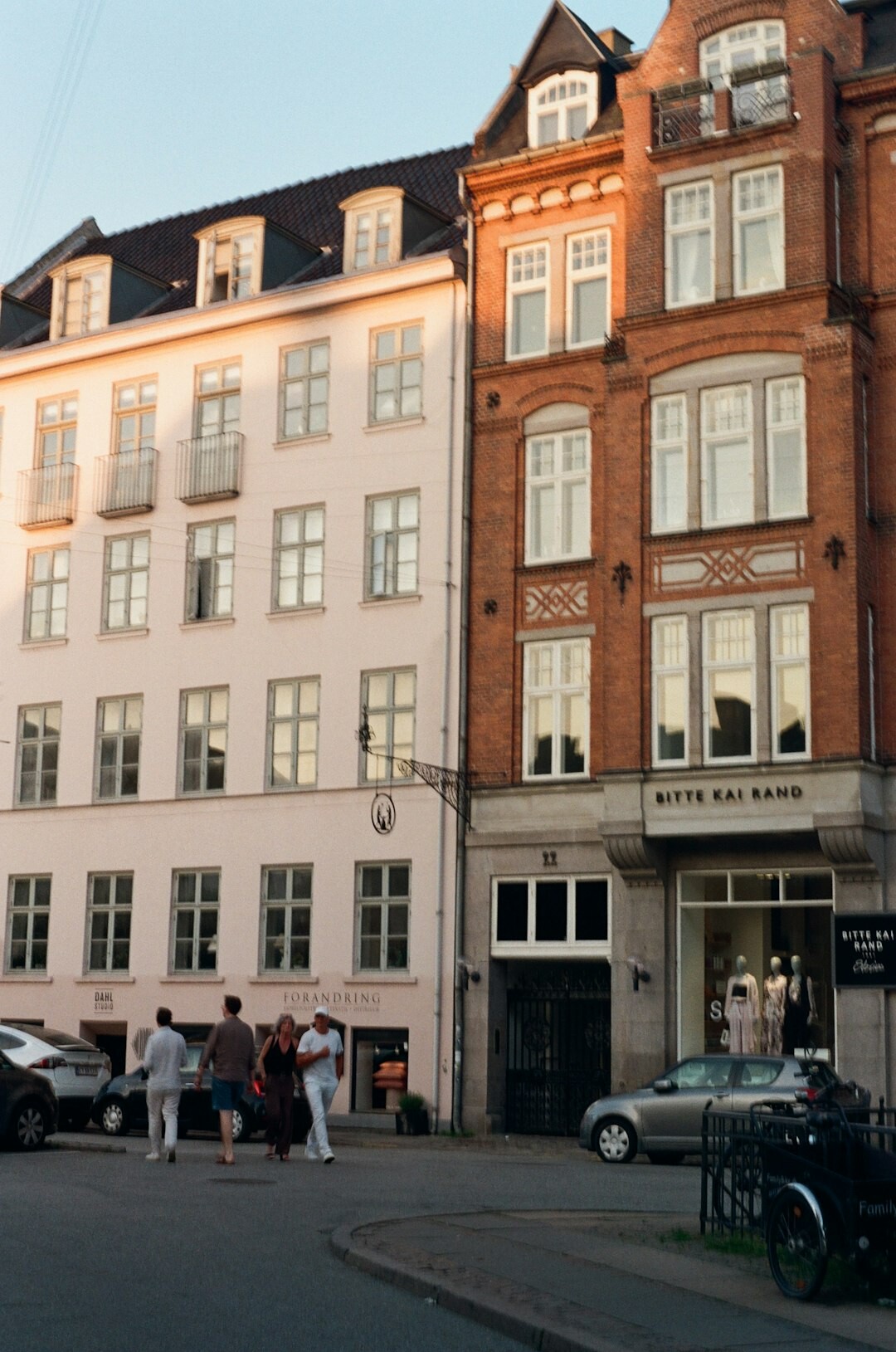 Portrait of a Danish documentary photographer holding a camera on a city street