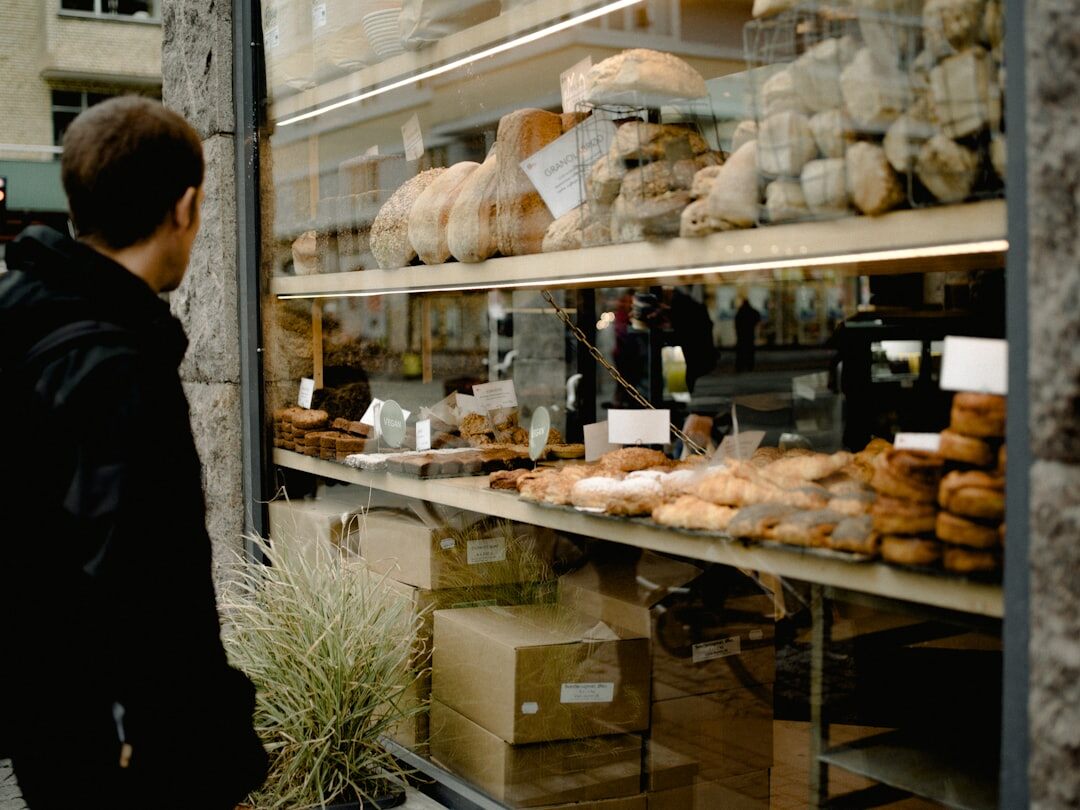 Portrait of a Danish baker standing in his small bakery surrounded by bread